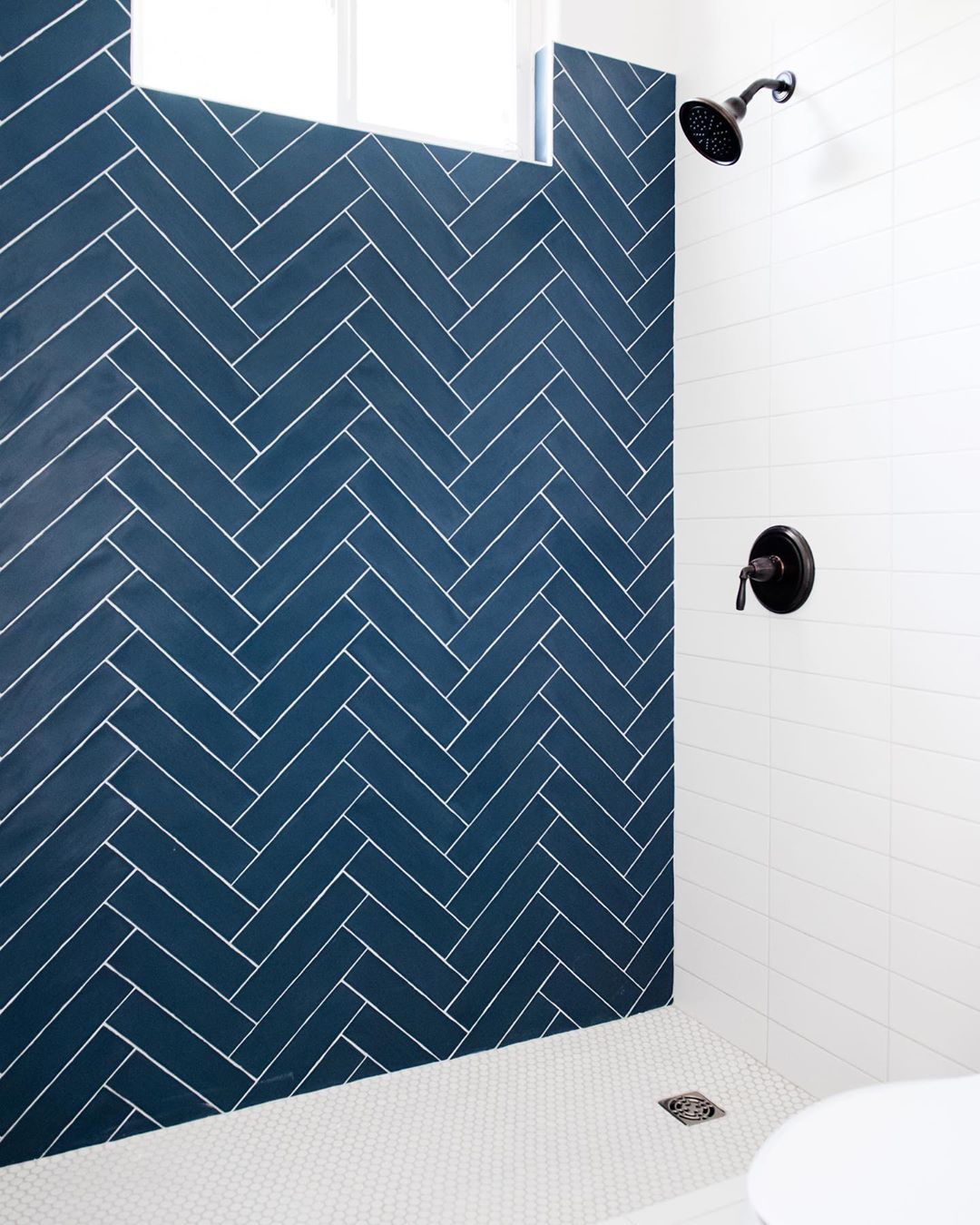 White grout on blue subway tile with white contrast tile used in shower environment 