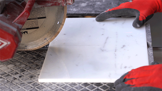 Man's hand aligning the tile for cutting