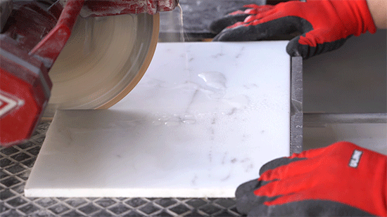 hands cutting tile with a watersaw